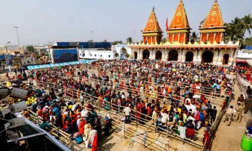 Gangasagar, West Bengal, India, 01_13_2024: Huge pilgrims made a que in front of Kapil Muni Temple to get entry inside the temple. Kapil Muni temple is a Hindu temple located on the Gangasagar in the Indian state of West Bengal. It is one of the holiest pilgrimage sites for Hindus and it is believed that Kapil Muni did Tapas here.
Ancient temples were temporarily built temples. According to legend, the first "Kapil Muni Temple" was built by Queen Satyabhama in 430 AD. The last temporary temple was built with bamboo. The bamboo temple was destroyed in the late 50s or early 60s. The first brick-built temple was built in 1961 for Rs 20,000, and the roof of the temple was made of asbestos. The former Chief Minister Bidhan Chandra Roy contributed Rs 11,000 to the construction of the temple. The construction of the temple was done by "S Chakraborty & Co." The temple was smaller in size than the present temple.
The new temple was built in 1974. As the temple and temple premises are on the banks of the Ganges River and the Bay of Bengal, sea and river water enters the temple and temple premises occasionally during High tide or cyclonic storms. A strong tropical cyclone named Yaas formed in the Bay of Bengal in late May 2021. Due to the impact of this storm, tidal water entered Kapil Muni's Ashram and temple